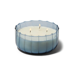 The Indigo Large Ribbed Glass Candle by Paddywax is designed to elevate tablescapes.   Bring a vintage touch to your next dinner party with these subtle and finely ribbed coloured glass vessels, available in both small and large sizes.  With a focus on sustainability, a repurposing tip is to try using the vessel as a votive for tea lights.  Top Notes: Peppered Woods  Middle Notes: Fern Leaf, Spiced Citrus  Base Notes: Oriental Musk
